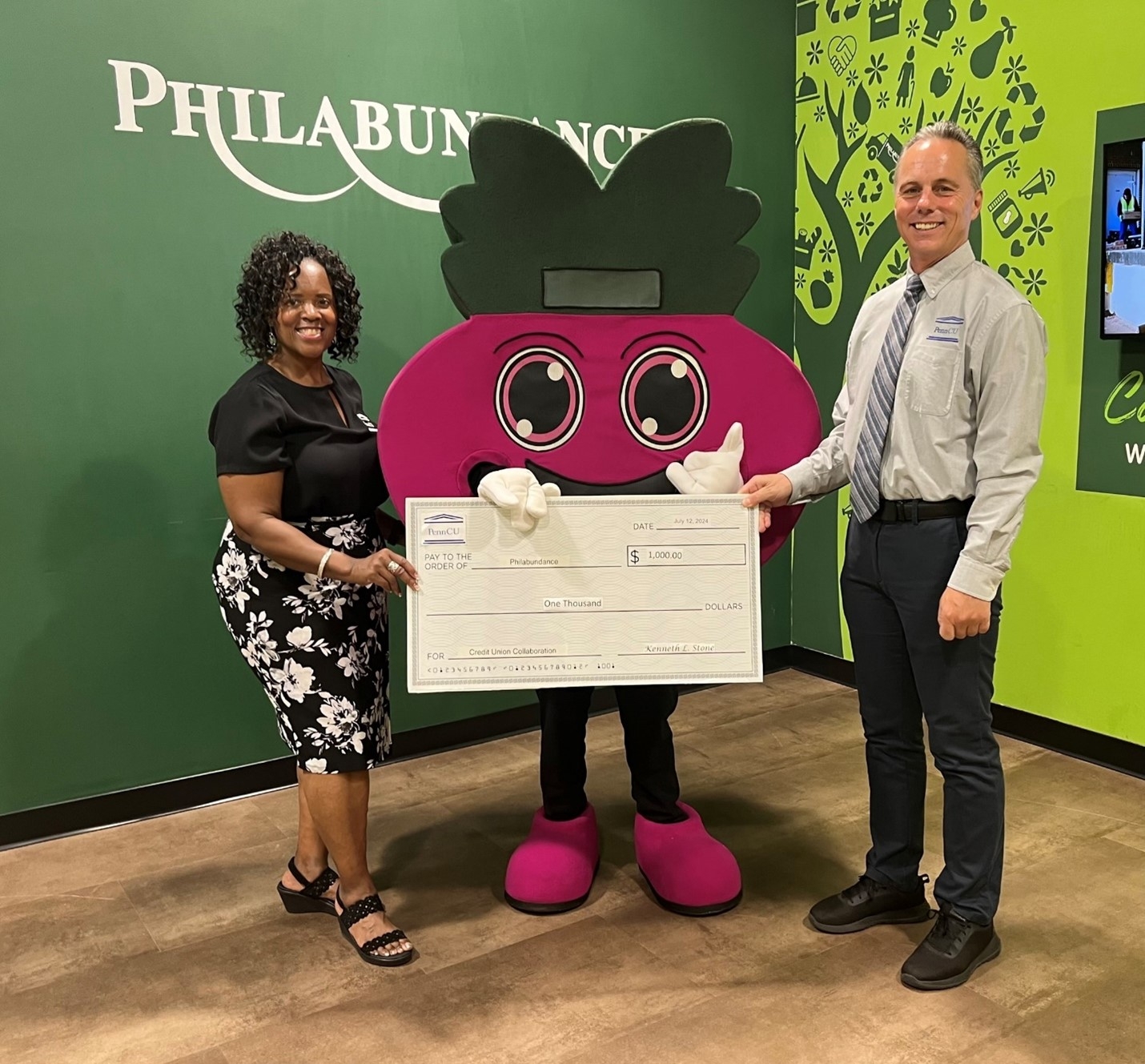 Penn Federal Credit Union presents a check to Philabundance in July 2024