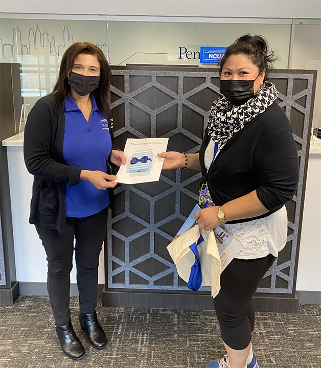 Adrienne Shewaski presents Credit Union Day Winner Maria Roberts-Reyes with her prize